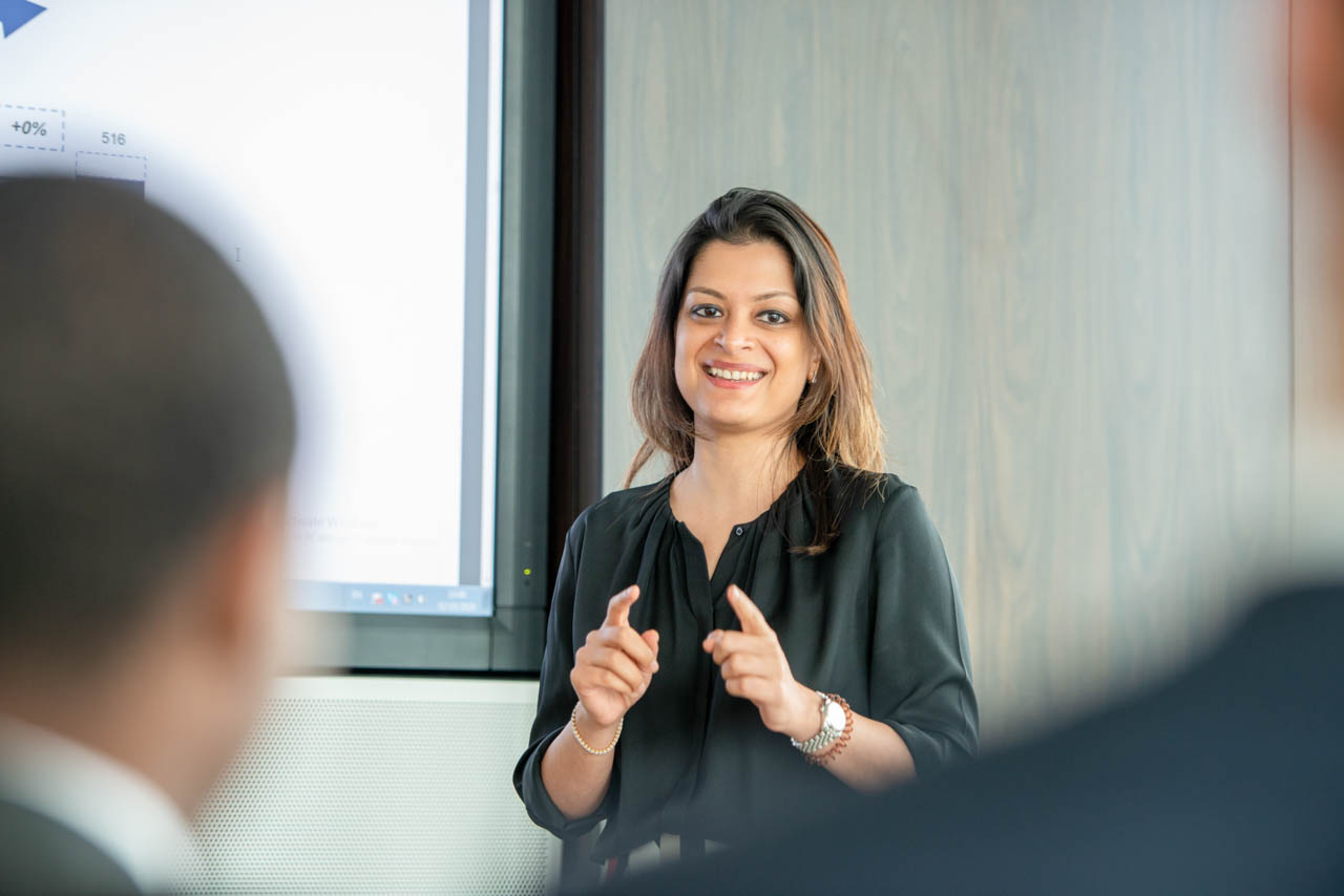 A woman standing, giving a presentation