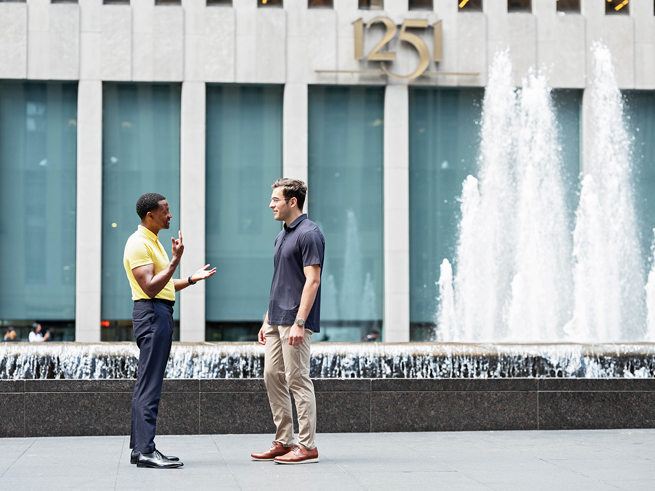 Two people having a conversation by a water fountain 